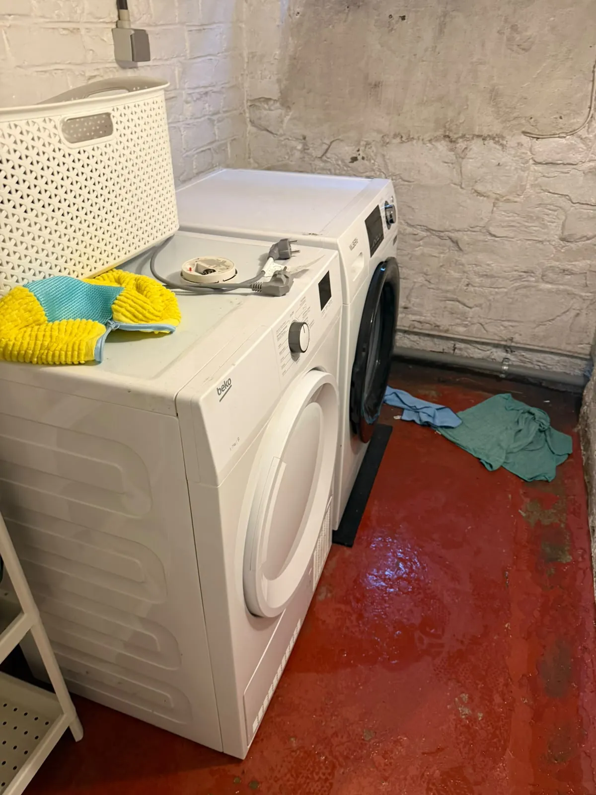 Buanderie en cave avec le sol inondé autour du lave-linge