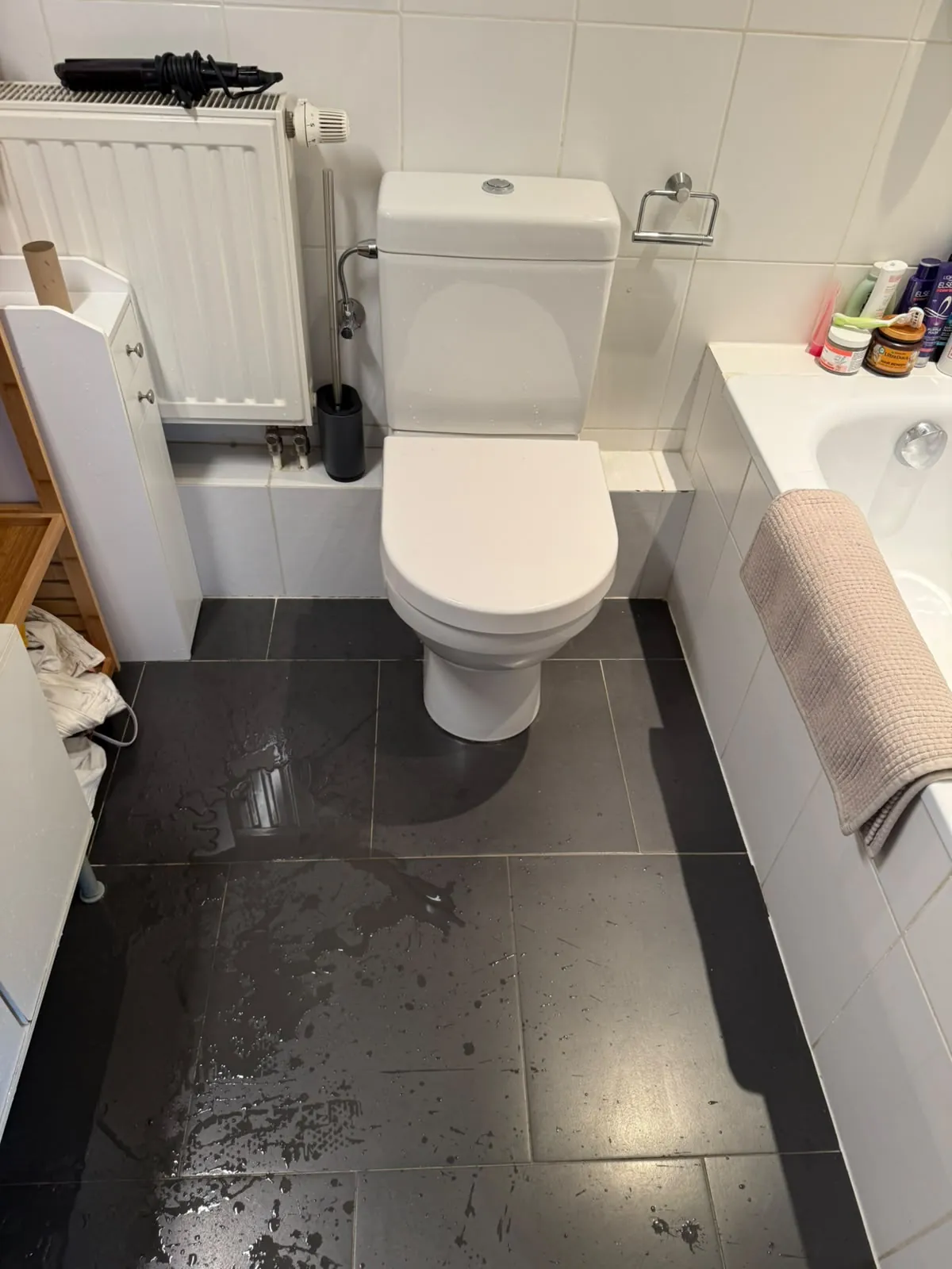 Sol de salle de bain inondé au pied du WC